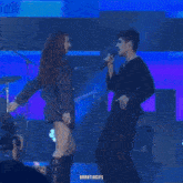 a man and a woman on a stage with the words urrutiagifs on the bottom right