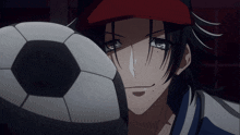 a man in a red hat holds a soccer ball in his hand