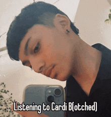 a man taking a picture of himself with the caption listening to cardi b ( botched )