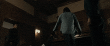 a man in a suit is jumping in the air in a dark room .