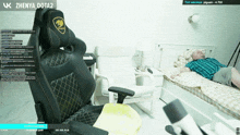 a man laying on a bed next to a chair that says zhenya dota2 on it