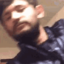 a man with a beard is making a funny face and looking at the camera .