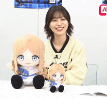 a woman is holding two stuffed dolls one of which is a smaller one
