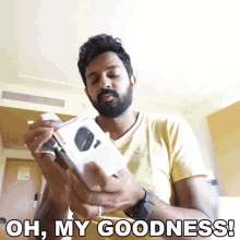 a man with a beard is holding a box with the words oh my goodness written on it
