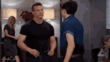 a man in a black shirt is standing next to a woman in a blue shirt .