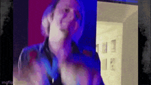 a man is making a funny face in front of a purple and blue background .