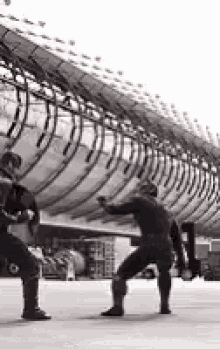 a couple of men are standing next to each other in front of a large airplane .