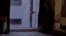 a person is walking through a doorway in a room at night .