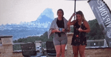 two women standing under an umbrella with a sign that says vip zone