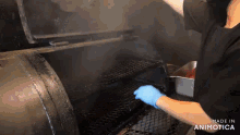 a person wearing blue gloves is cooking in a smoker made in animatica