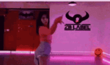 a woman is dancing in a dance studio in front of a sign that says zb label .