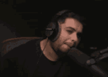a man wearing headphones is sitting in front of a microphone