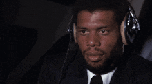a man wearing a suit and tie is wearing headphones