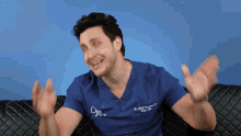 a man wearing a blue scrub top with the letters dm on the front
