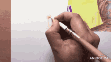 a person is holding a brush in their hand and drawing on a piece of paper