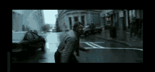 a blurry picture of a man walking down a street in the rain