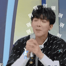 a man is holding a microphone with chinese writing around him