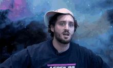 a man with a beard wearing a hat and a shirt that says aspen on it