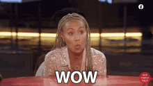 a woman sitting at a table with wow written on the table