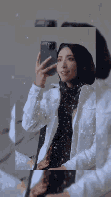 a woman in a hijab takes a selfie with her phone