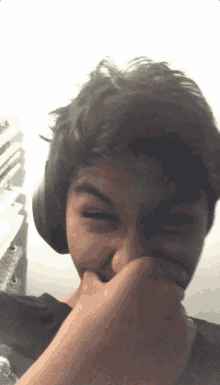 a young boy wearing headphones is covering his nose