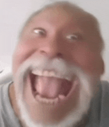 a man with a beard and mustache is making a funny face with his mouth open .