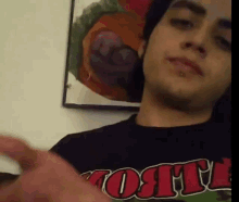 a man wearing a black shirt that says t.o.t.i.