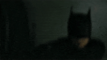 a man in a batman costume is flying through the air in a room .