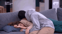 a man is hugging a woman who is sleeping on a couch ..