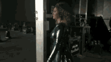 a woman in a blue dress is standing in a dark room