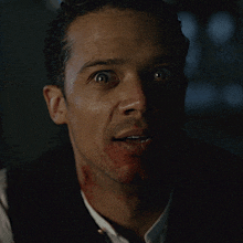 a close up of a man 's face with blood on his face