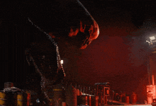 a person standing in a dark room with a red light