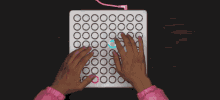 a person 's hands are typing on a white keyboard with circles on it