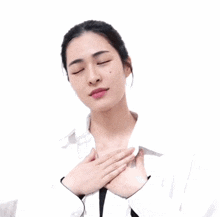a woman in a white shirt is smiling and holding her hands to her chest