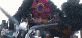 a giant robot is destroying a city in a video game with smoke coming out of it .