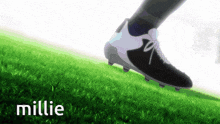 a person wearing a pair of black and white soccer cleats walking on a grassy field