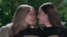 two women are kissing each other on the cheek