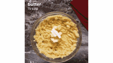 a bowl of mashed potatoes with butter being added