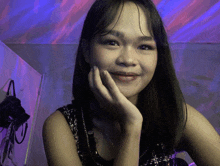 a woman with a hand on her chin is smiling