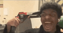 a man is holding a toy gun in front of his face .