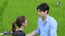 a man and a woman are looking at each other in front of a green field with the number 7 in the corner