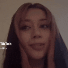 a close up of a woman 's face with the words tiktok ardilix on the bottom