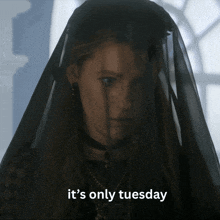 a woman with a black veil on her head and the words it 's only tuesday below her