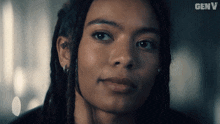 a close up of a woman 's face with a genv logo in the background