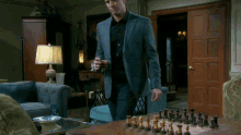 a man standing in front of a chess board