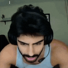 a man with a beard is wearing headphones and a headset .