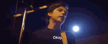 a man is playing a guitar in front of a microphone and says okay .