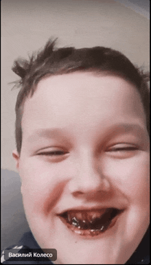 a young boy with his eyes closed is smiling with the name vasiliy колесо on the bottom left
