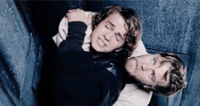 a man and a woman are laying on top of each other on a staircase .