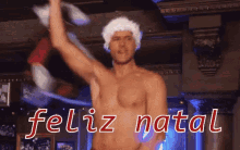 a shirtless man wearing a santa hat is dancing with the words feliz natal written in red